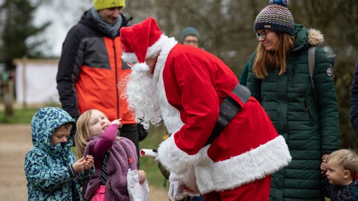 Father Christmas engaging with family at Longshaw's Christmas Tree Festival